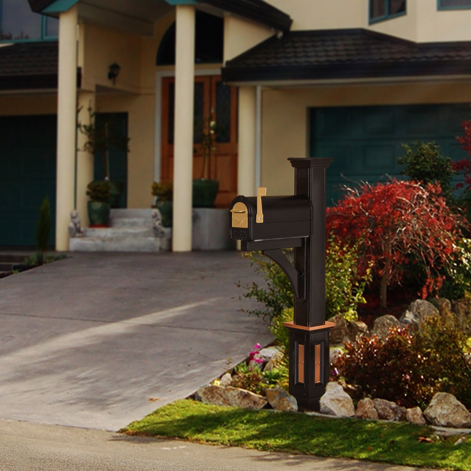 Black Madison mailbox post with copper accents beside a driveway