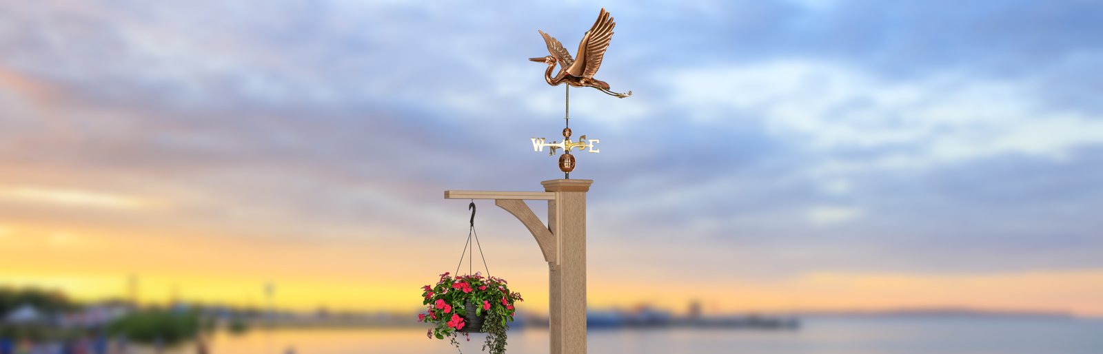 Weathervane post with a copper heron at sunset