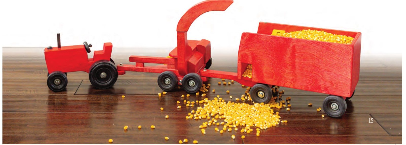 Red tractor pulling the harvester and forage wagon full of corn kernels