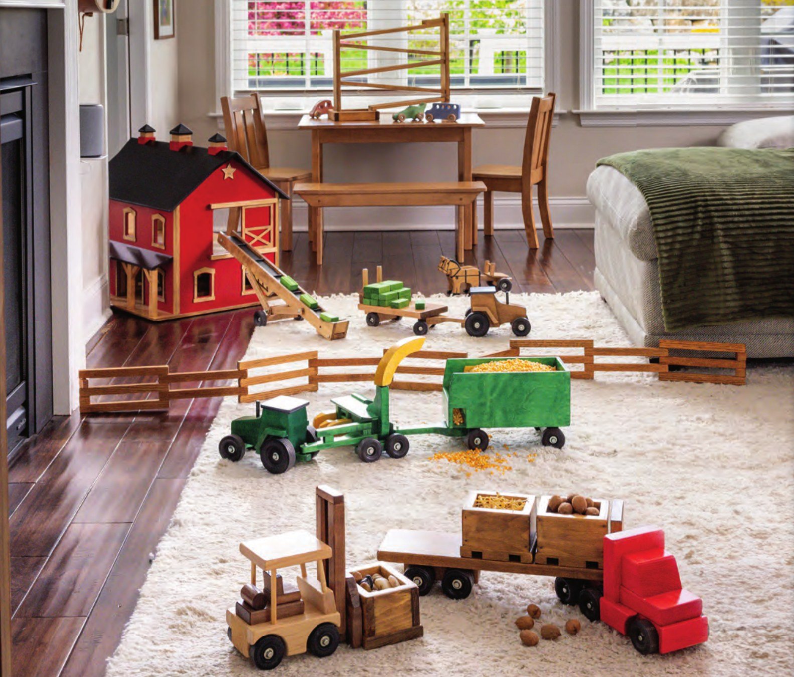 Lapp's wooden barn, elevator, tractors, harvester and forage wagon set up on a living room rug with a wooden fence