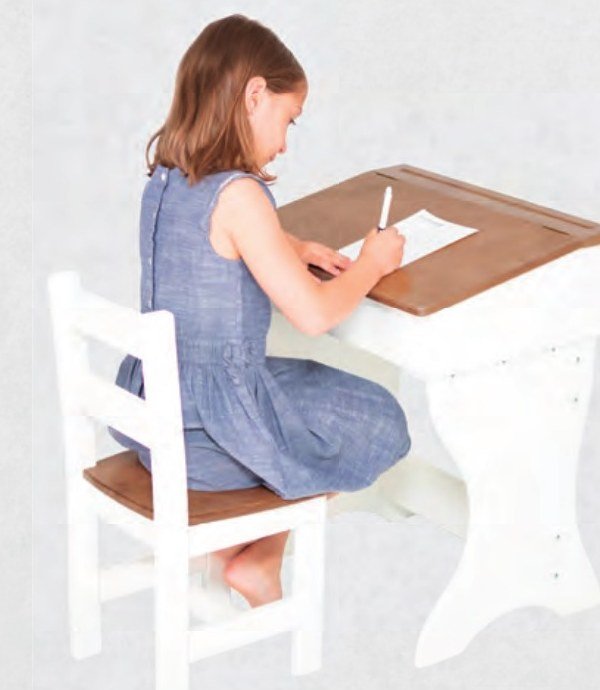 Girl drawing at a white and harvest child's desk with a white chair