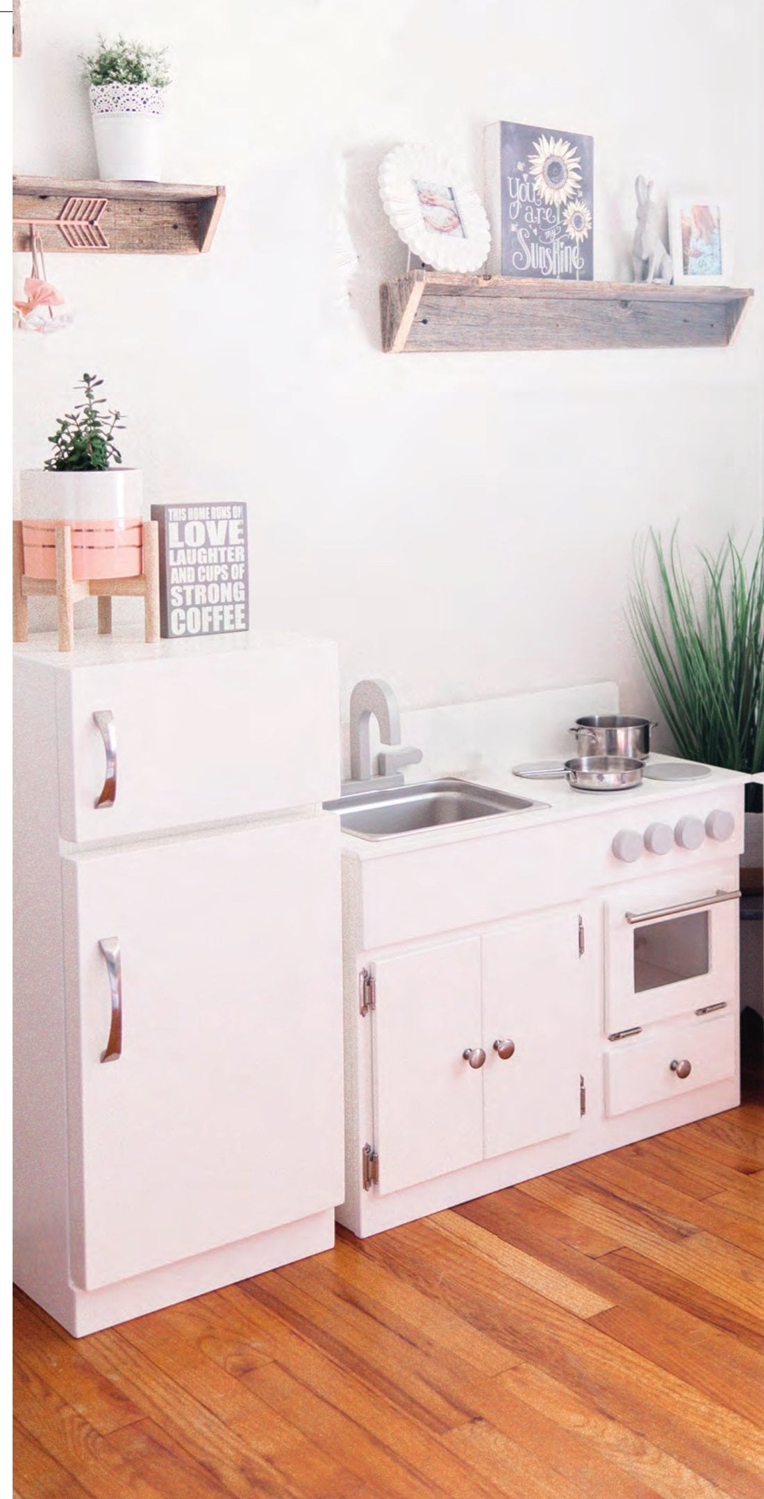 White Lapp's play kitchen: refrigerator and sink and stove set up in a bright playroom
