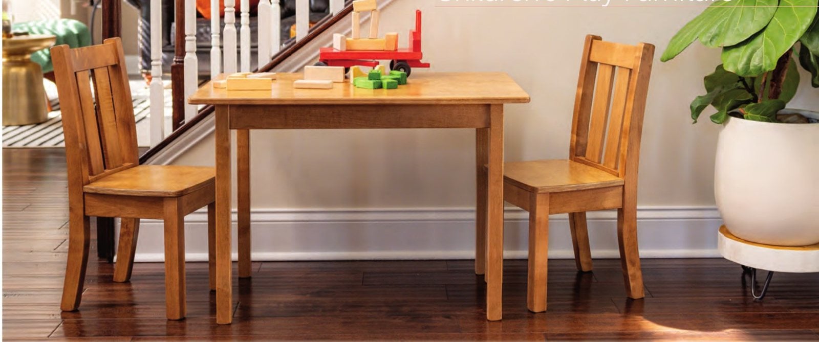 Kid's wooden table with two chairs set up in a dining room