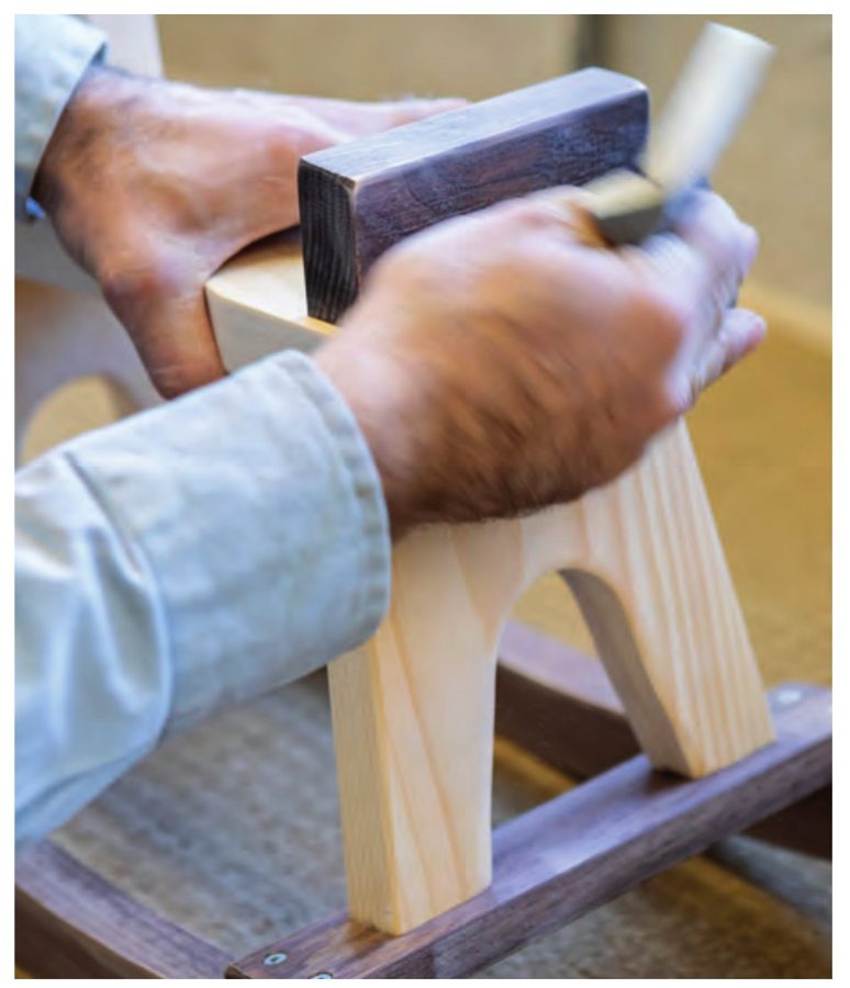 Sanding a wooden rocking horse by hand
